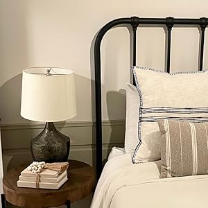 Beige decorative books with beaded tassel on bedroom end table.