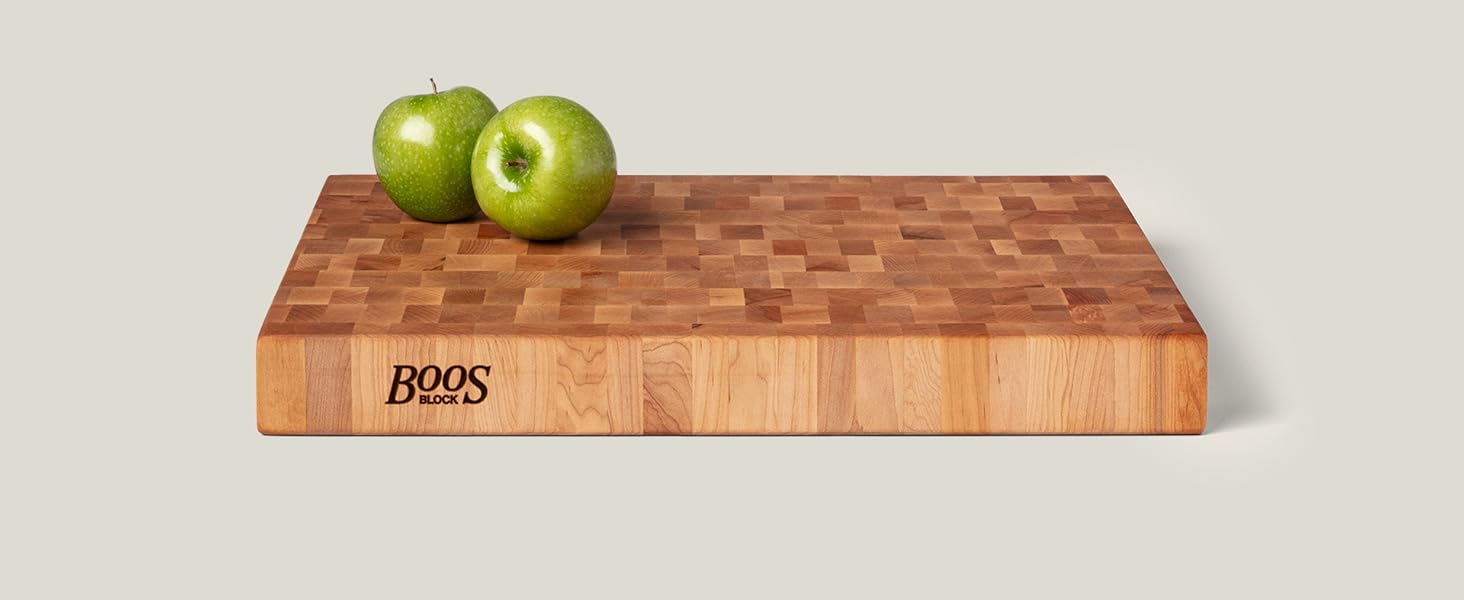 Apples on a wooden chopping block on light background.