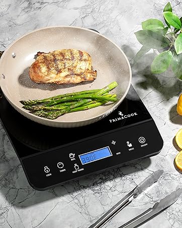 PrimaCook Single Burner Induction Cooktop used to prepare chicken and asparagas in a frying pan