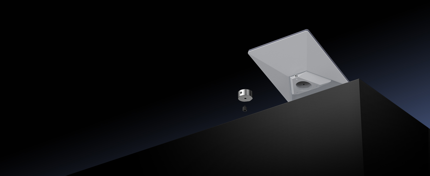Minimalist product photo showing small metallic cube or mounting bracket against dark background with dramatic lighting.