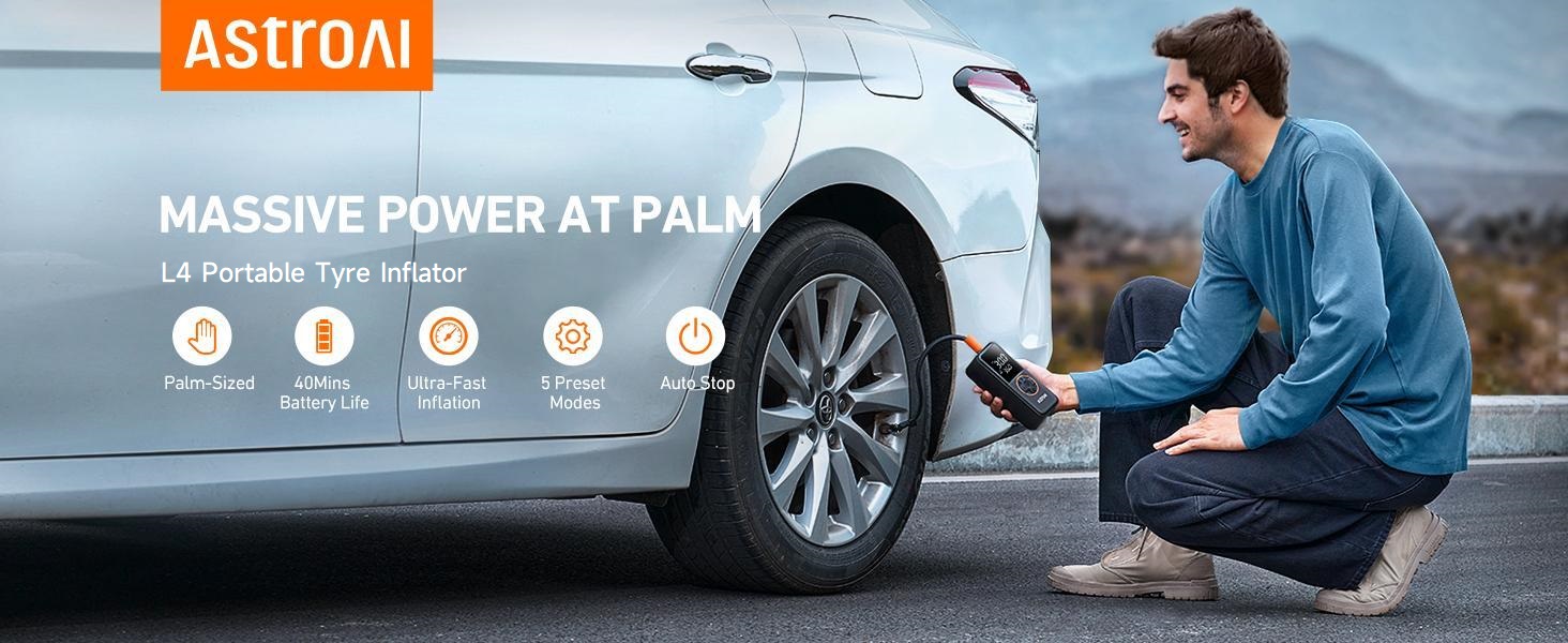 Man kneeling by car tire, using a portable device. Text overlay reads 'ASTROAI' and 'MASSIVE POWER AT PALM', suggesting a compact power tool or air compressor.