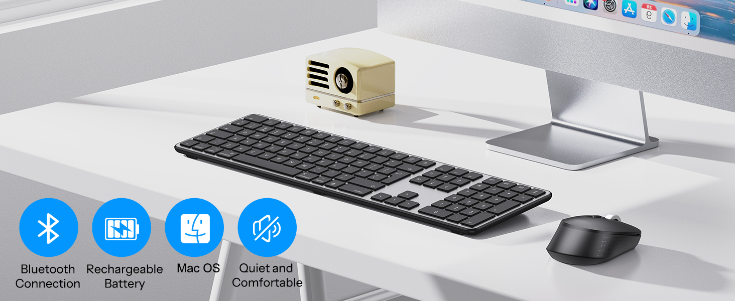 Desktop setup with a compact beige mini projector, wireless keyboard, mouse, and computer monitor. Four blue icons indicate Bluetooth and Mac OS compatibility features.