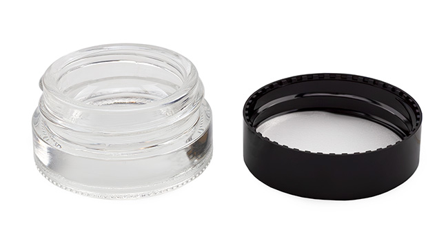 Lid off of jar sitting next to jar on white background.