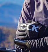 Close-up of navy blue backpack strap and portion of the bag against white background.