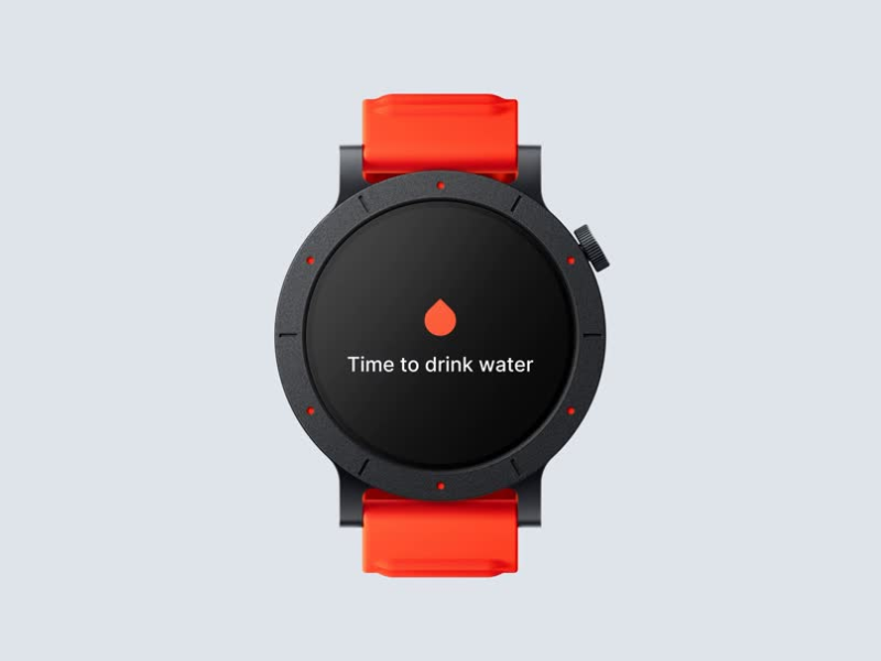 El texto dice «Es hora de beber agua» en la pantalla circular negra del reloj inteligente con una banda de color rojo anaranjado brillante sobre un fondo gris claro.