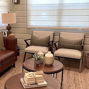 Beige decorative coffee table book stack in rustic farmhouse modern living room.