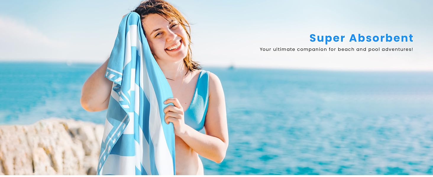 Woman at beach drying herself with a blue towel. Text overlay reads 'Super Absorbent', suggesting the towel's key feature.