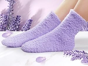 Weiche, flauschige lavendelfarbene flauschige Socken mit dekorativen Lavendelzweigen im Hintergrund auf