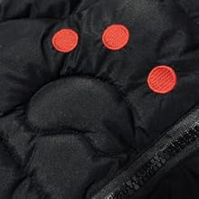Close-up of black fabric with three red circular buttons or patches visible against the dark material.