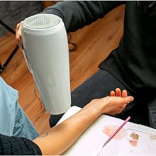 makeup artist using hair dryer on arm to make silicone compound dry faster