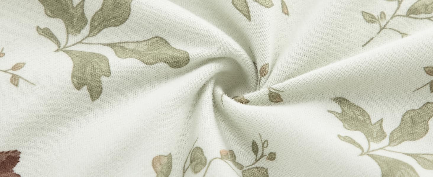 Detailliertes Muster aus hellgrünem und weißem floralem Textildesign mit zarten Blattmotiven in Nahaufnahme.