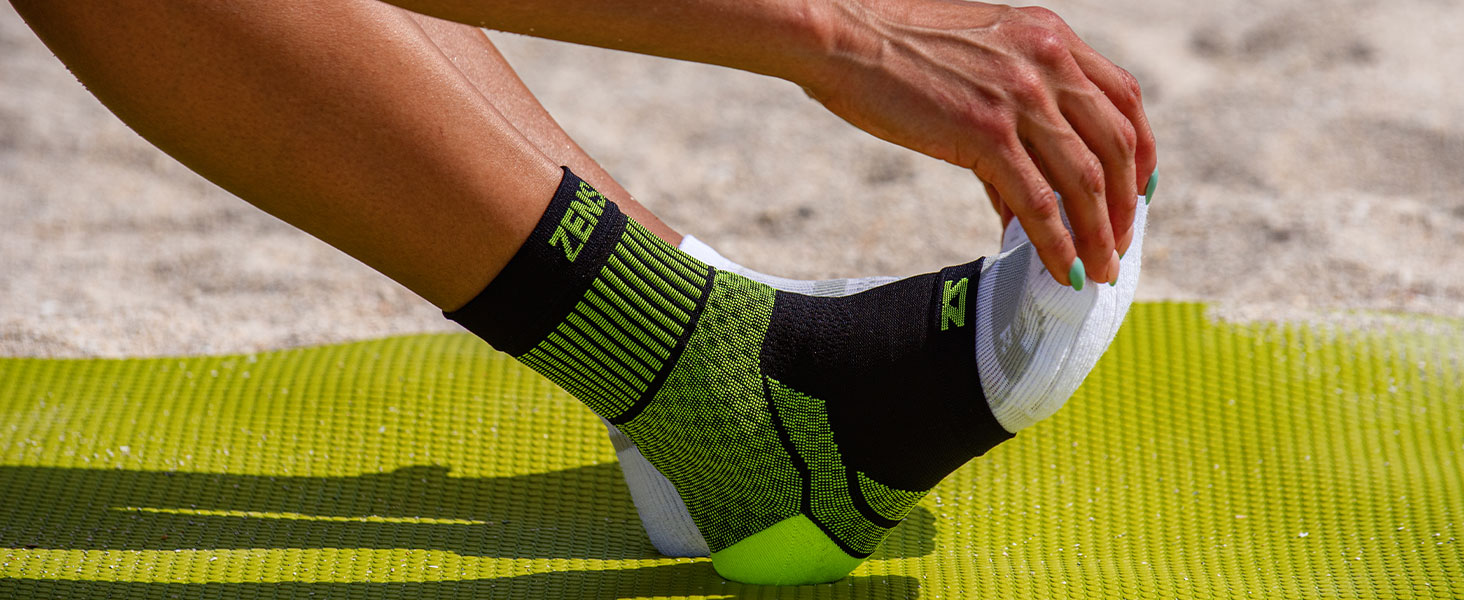 Image of the neon ankle sleeve on an athlete on the beach