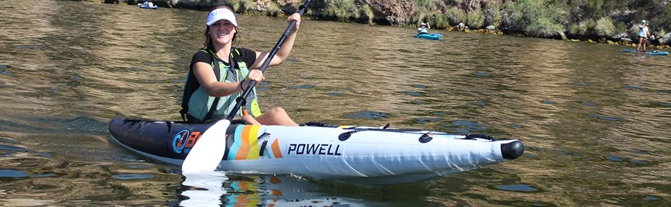 Young woman paddling on a lank on a Buoy Watersports Powell single seat inflatable kayak