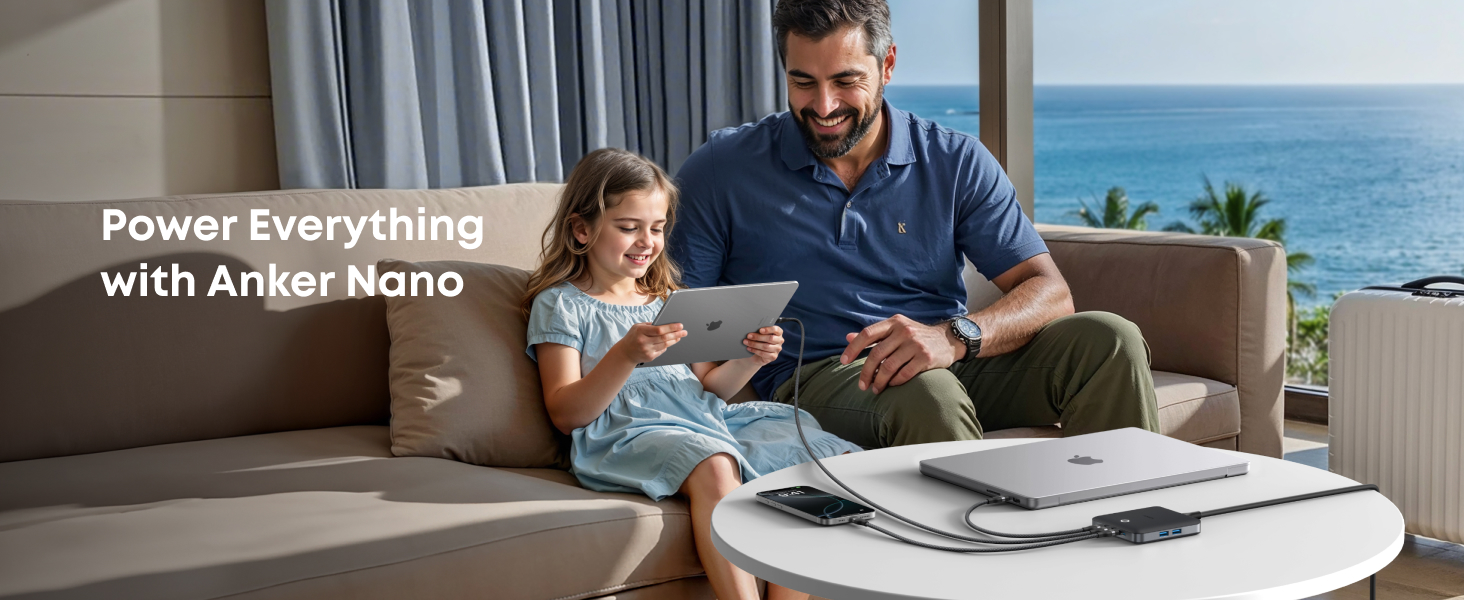 Anker Nano power products displayed on coffee table in coastal living room setting. Multiple charging devices shown against ocean view backdrop.