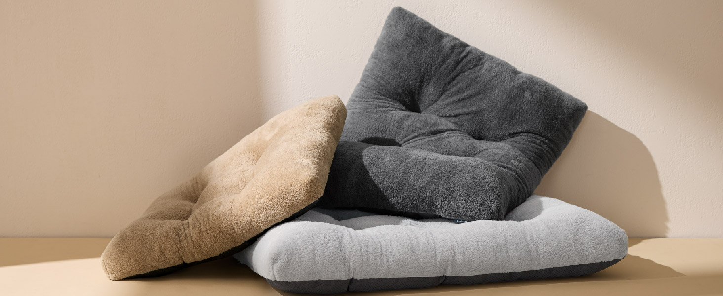 Drei quadratische Bodenkissen in verschiedenen Farben: Beige, Dunkelgrau und Hellgrau. Die Kissen haben eine weiche, plüschige Textur und ein getuftetes Design. Sie sind auf einem neutralen Hintergrund angeordnet