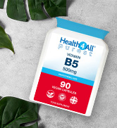 White bottle of vitamin B5 supplements on a white surface with green leaves. Label shows 90 capsules, 500mg dosage.