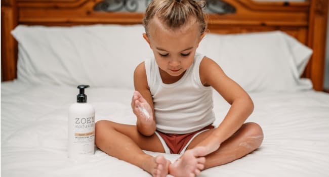 Child Applying Lotion in Bed Before Bed Time