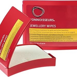 dans une boîte rouge. Le produit est montré ouvert, laissant apparaître des lingettes blanches à l'intérieur pour nettoyer les bijoux