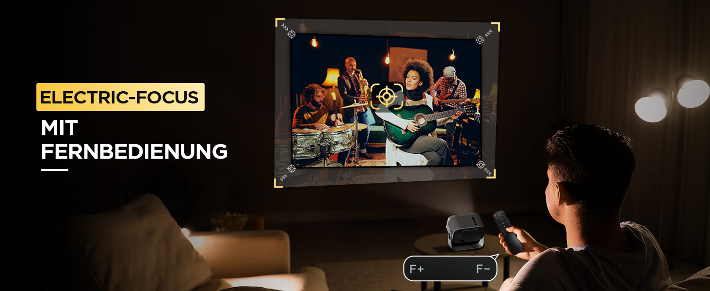 Personne utilisant la télécommande du projecteur « ELECTRIC-FOCUS MIT FERNBEDIENUNG ». L'écran montre un groupe de personnes à une table.