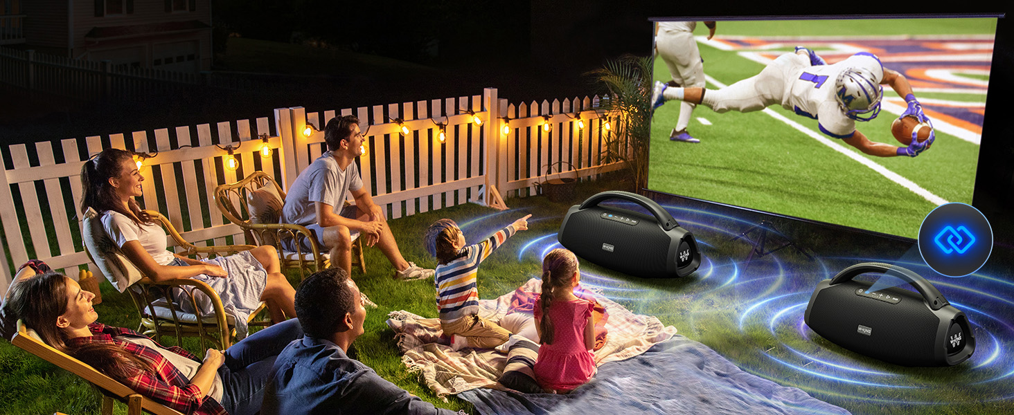 a family sitting on a blanket watching a soccer game on a blanket.