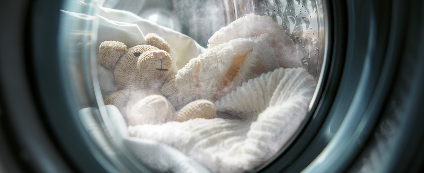 Κοντινό πλάνο του τυμπάνου του πλυντηρίου ρούχων κατά τη λειτουργία, με τα λευκά ρούχα να πέφτουν με κυκλική κίνηση