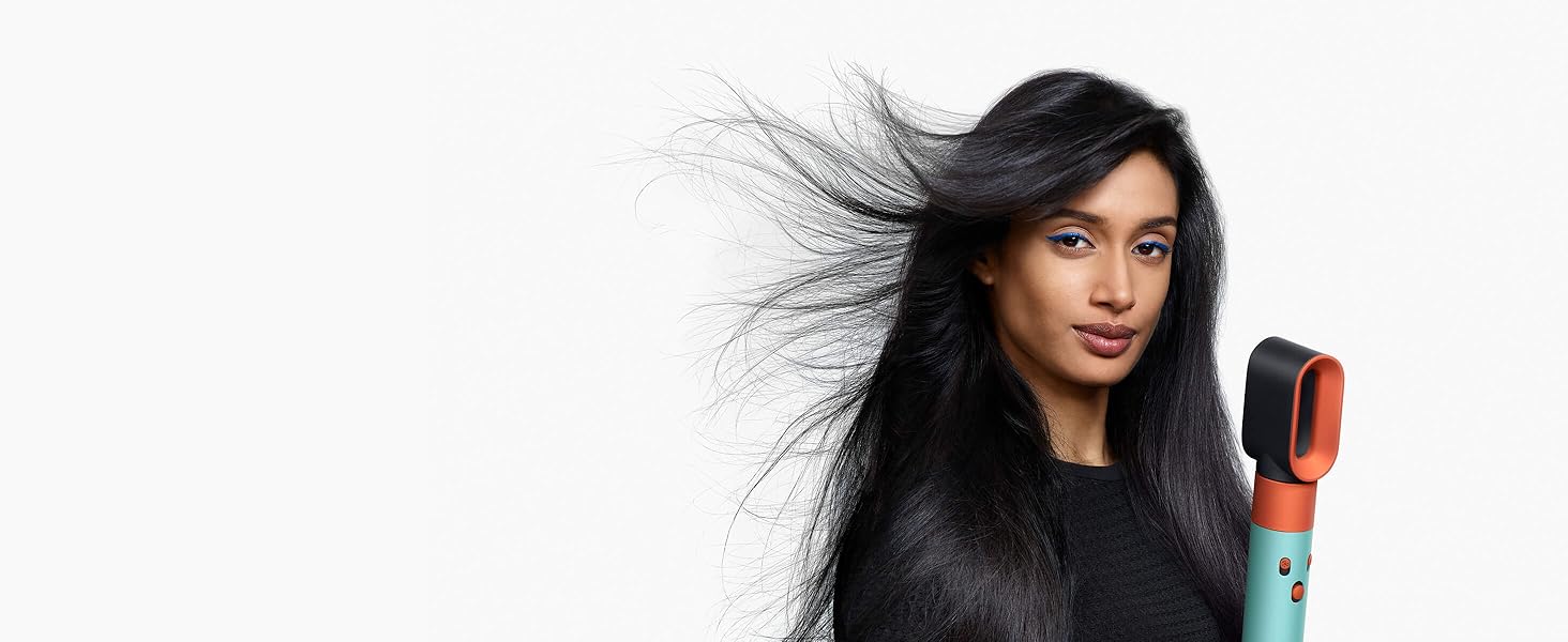 A model with long, dark hair uses the Fast dryer attachment to rough dry her hair.