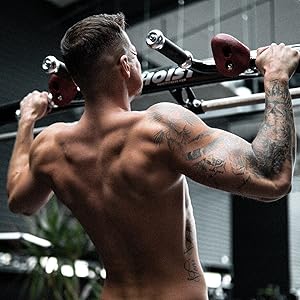 Man in a gym doing pull ups.