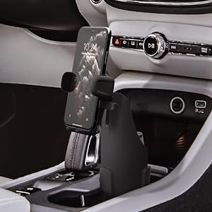 Car interior featuring a smartphone mount attached to the center console. The mount holds a phone displaying a map application.
