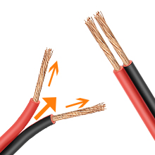 Close-up of exposed electrical or speaker wire with red and black insulation, showing copper conductors.