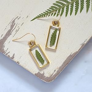 A pair of Olive Bella fern leaf earrings.