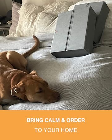 A relaxed dog laying on top of a bed with two folded LinenMate's a laying against the pillows.