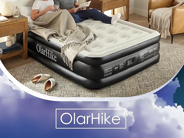 Inflated air mattress with gray and black design shown in a home setting with blanket. Features raised height and reinforced edges.
