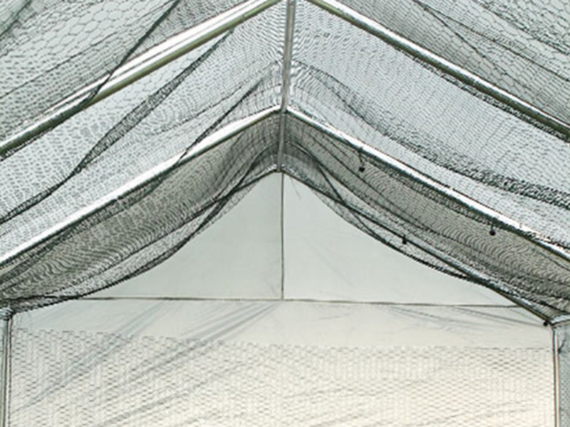 Innenansicht eines großen, weißen Stoffgewächshauses oder einer Zeltkonstruktion mit Metallrahmen. Wände und Decke bestehen aus durchscheinendem Material