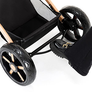 Close-up of a stroller's black wheel and lower frame. The wheel has a sleek design with silver accents, attached to a black fabric base.