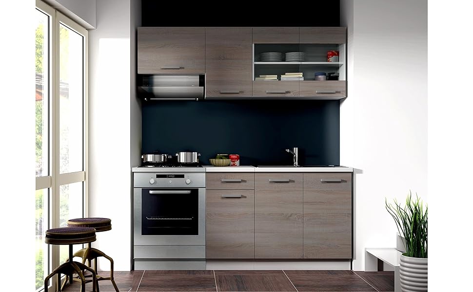 Modern compact kitchen with gray cabinets, black backsplash, stainless steel oven, and window. Includes countertop, upper shelving, and potted plant.