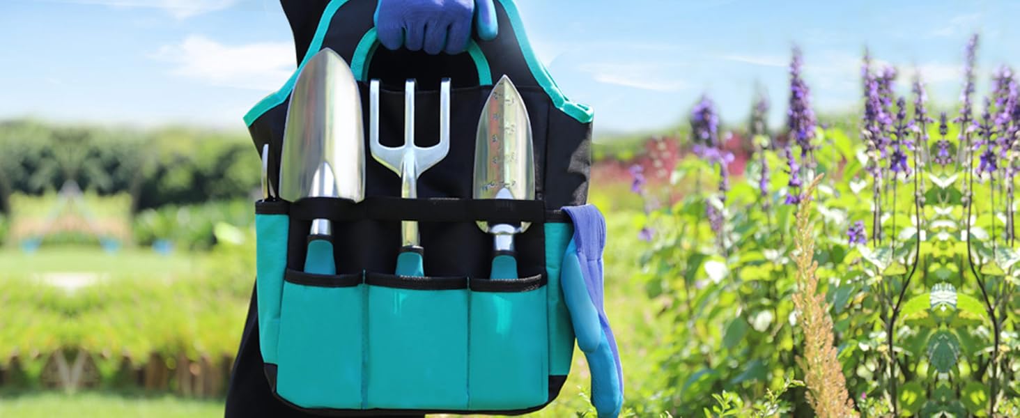 Teal gardening tote with hand tools including trowel, fork, and pruning shears. Held by gloved hands in a lavender field, showcasing portability and outdoor use.