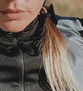 Close-up view of person wearing dark waterproof jacket in rainy conditions, demonstrating water resistance of the fabric.