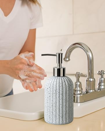 A ribbed soap dispenser, while a person washes their hands, showcasing its practical use.