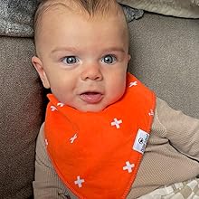 baby boy relaxing in orange bib