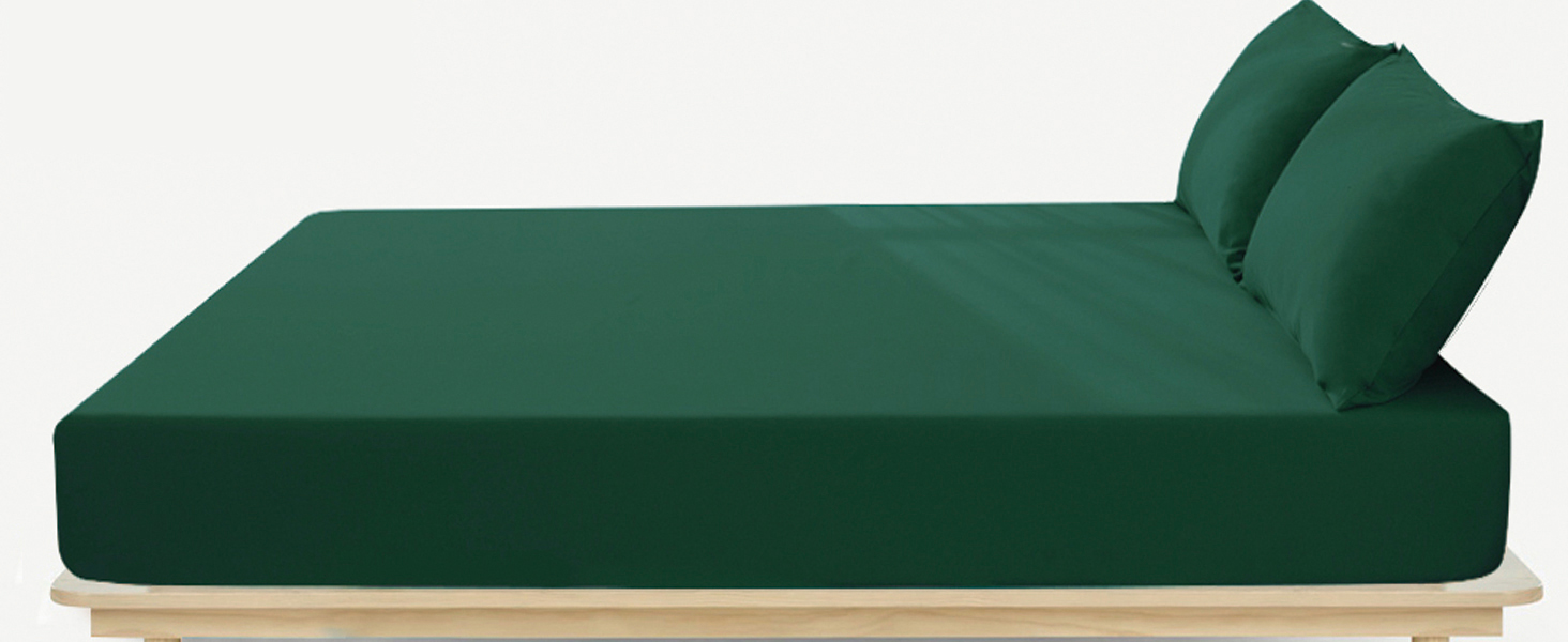 Green upholstered daybed or chaise lounge with wooden base. Features a thick mattress and two back pillows in matching dark green fabric.