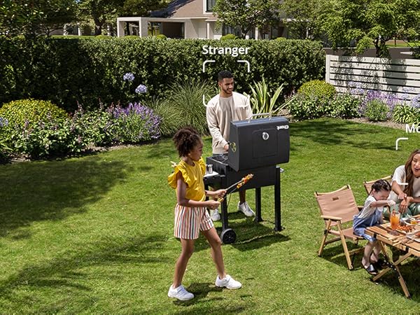 a man and a woman playing a game on a grill in a backyard.