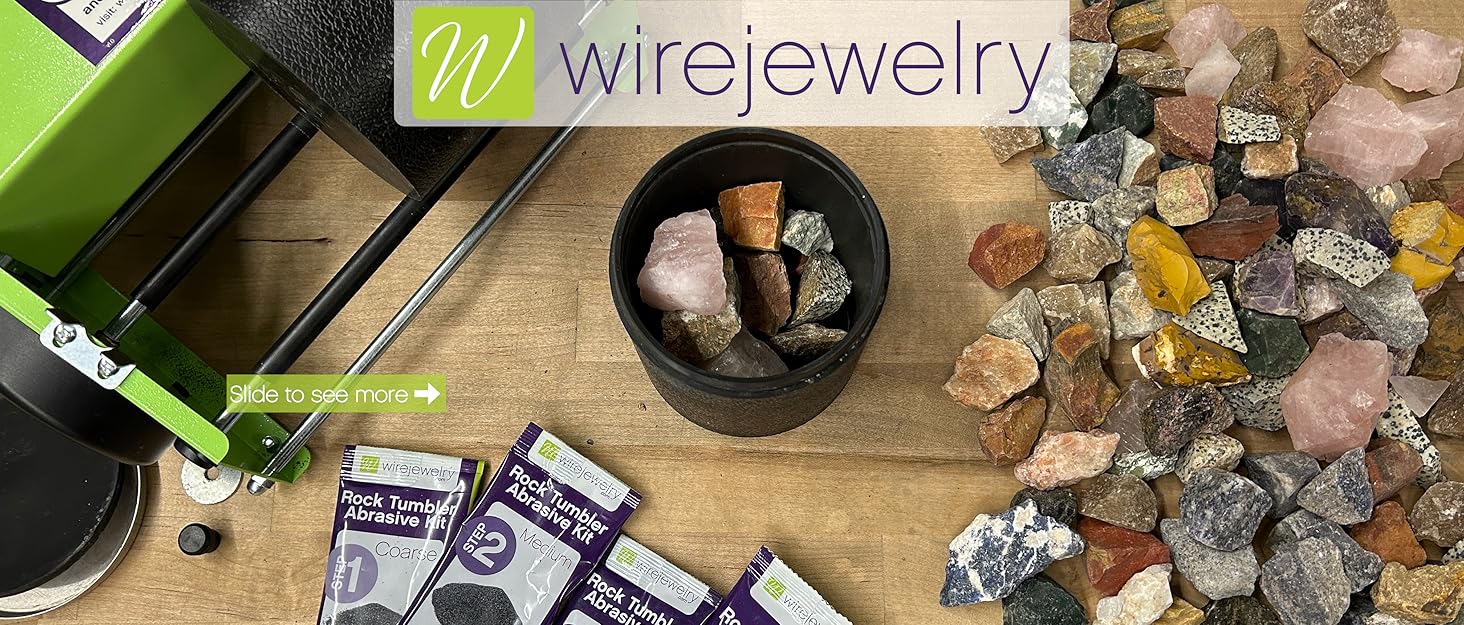 Close-up image of a rock tumbler, filled barrel, rocks, and grit packets on a workbench.