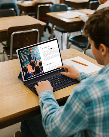 Person using tablet device with attached keyboard in classroom setting, viewing digital content on screen.