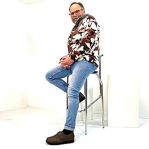 Mann sitzt auf Podest und trägt das schwarze Modell des Natural Feet Klaas XL.