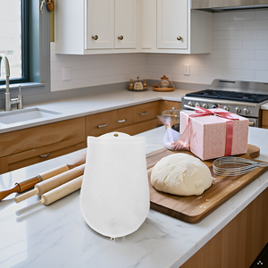 A rustic wooden table with a bowl of flour, a rolling pin, and the product lying next to it.