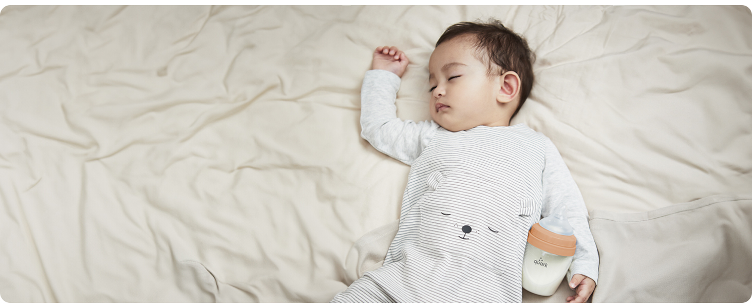 Baby sleeping with BuubiBottle Mini orange baby bottle