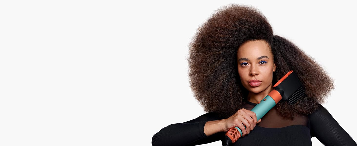 A model with coily hair uses the Wide-tooth comb attachment to shape and lengthen her natural hair.
