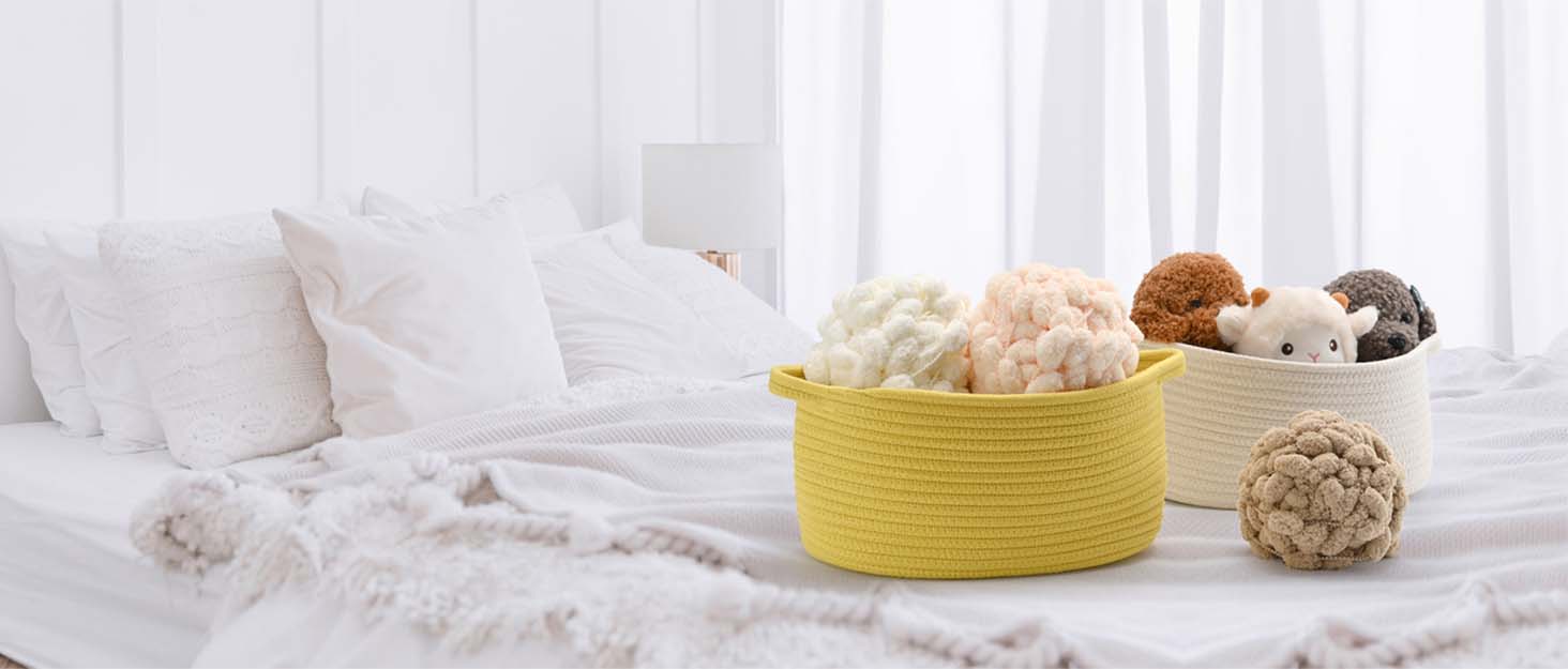 several storage baskets on the tidy bed, which are filled with wool balls and doll toys
