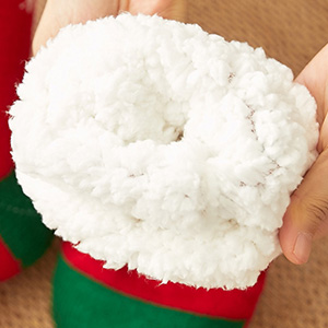 Close-up shots of white plush or sherpa material, appearing soft and fluffy against red and green backgrounds.
