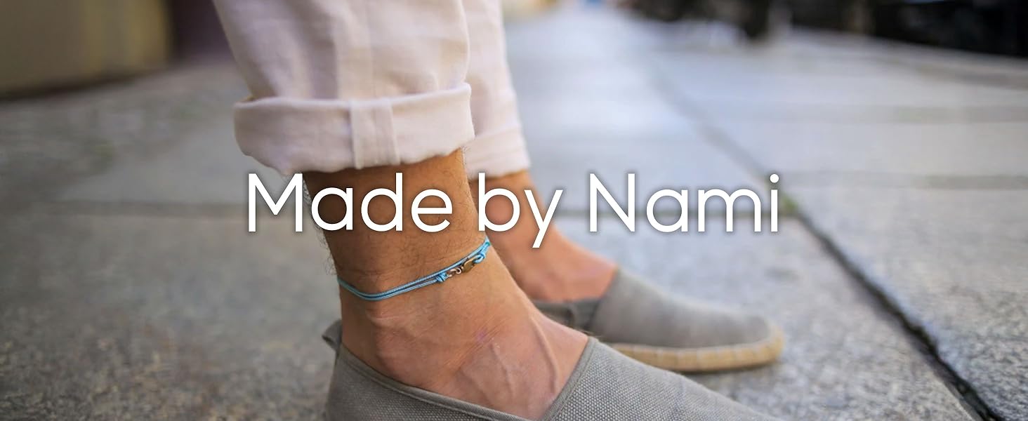 Man wearing blue minimalist anklet and gray espadrilles with text Made by Nami on stone walkway